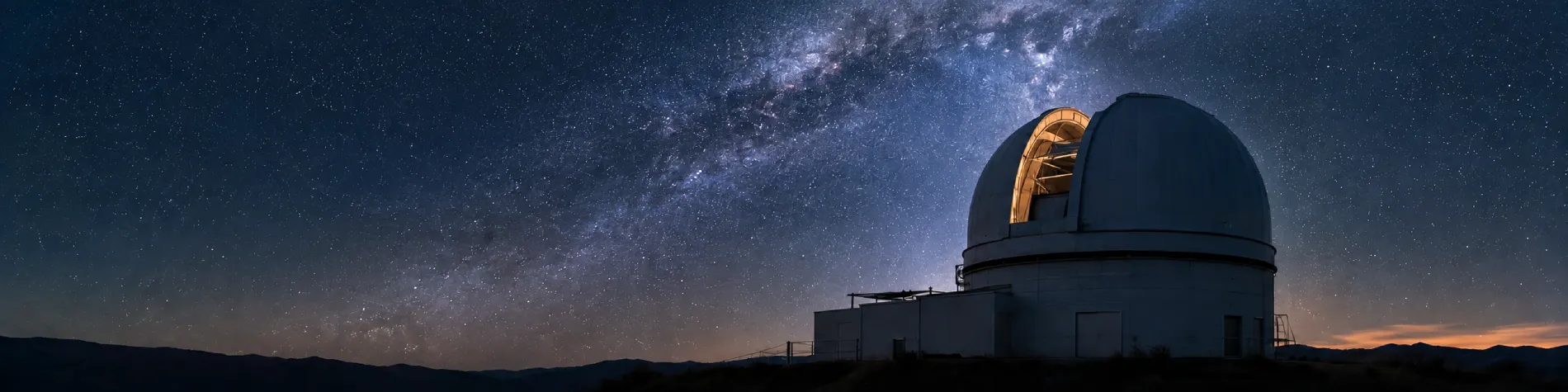 Observatoire astronomique sous un ciel nocturne étoilé traversé par la Voie lactée.